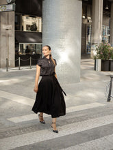 A woman wears a black dress